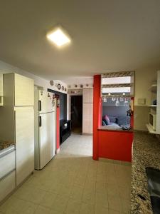 een keuken met een koelkast en een kamer met een bed bij De norte a sur in Puerto Madryn