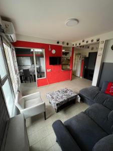 a living room with a couch and a red wall at De norte a sur in Puerto Madryn