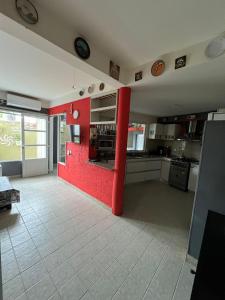 uma cozinha com uma parede vermelha num quarto em De norte a sur em Puerto Madryn