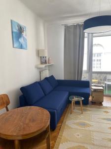 ein Wohnzimmer mit einem blauen Sofa und einem Tisch in der Unterkunft Wisła River Apartment in Warschau