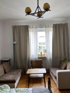 ein Wohnzimmer mit einem Sofa und einem Tisch in der Unterkunft Wisła River Apartment in Warschau