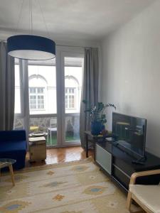 ein Wohnzimmer mit einem Flachbild-TV und einem Sofa in der Unterkunft Wisła River Apartment in Warschau