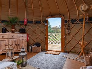 a room with a yurt with a door open at Little West View in Chard