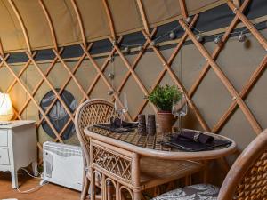 a table in a yurt with a table and chairs at Little West View in Chard