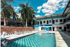 una piscina frente a un edificio con sillas y una casa en Hotel Villa Alicia, en San Jerónimo
