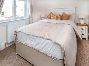 a bedroom with a large white bed with a window at Bishopfield House in Dornoch