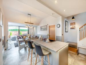 een keuken en een woonkamer met een tafel en stoelen bij Foremans Cottage in Skidby