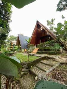 a house in the middle of a garden with stairs leading up to it at Green Forest Tangkahan in Tangkahan
