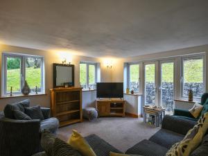 a living room with two couches and a flat screen tv at Tir-y-coed in Gwernymynydd