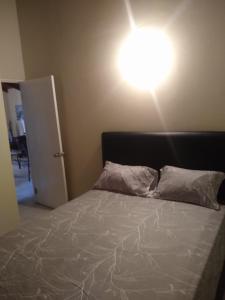 ein Schlafzimmer mit einem Bett und einer Lampe an der Wand in der Unterkunft Aquamarine Ave in Montego Bay