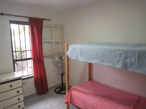 ein Schlafzimmer mit einem Etagenbett und einem Fenster in der Unterkunft La casa de Tilili in Puerto Iguazú