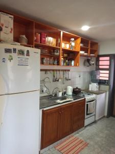 a kitchen with a white refrigerator and a sink at La casa de Tilili in Puerto Iguazú