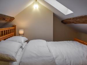 a bedroom with a bed with white sheets at Little Jacks Cottage in Todmorden