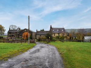an old house with a dirt road in front of it at Little Jacks Cottage in Todmorden
