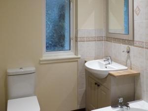 La salle de bains est pourvue de toilettes, d'un lavabo et d'un miroir. dans l'établissement Barr Beithe Upper, à Dallavich