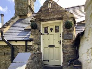 an old stone house with a white door at Top Cottage in Barmouth