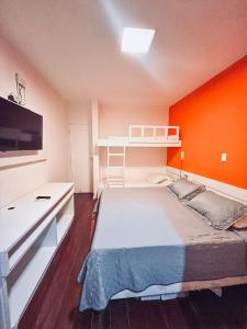 een slaapkamer met een groot bed met een oranje muur bij Hotel Marinas Tamandaré in Tamandaré