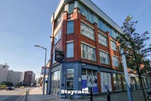 a building on the corner of a city street at Bright & Central Apt - With Great Transport Links in Stockport
