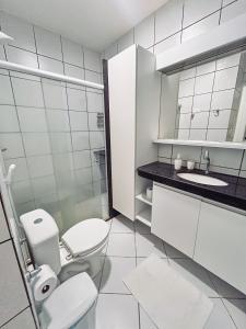 een witte badkamer met een toilet en een wastafel bij Hotel Marinas Tamandaré in Tamandaré