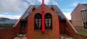 a brick building with a red pole in front of it at Aljaba in Esquel