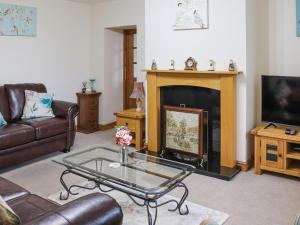 a living room with a couch and a fireplace at Plas Madog in Llanuwchllyn