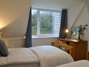 um quarto com uma cama e uma janela em Clachries Cottage em Boreland of Colvend