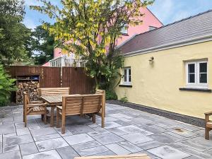 een patio met 2 banken en een tafel bij Cowslip Cottage in Roch