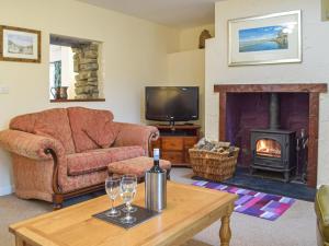 een woonkamer met een bank en een open haard bij Cowslip Cottage in Roch