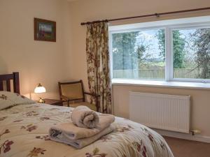 una camera da letto con un letto e un asciugamano sopra di Cowslip Cottage a Roch