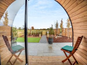 a patio with two chairs and a view of a yard at The Hive - Uk45565 in Longford