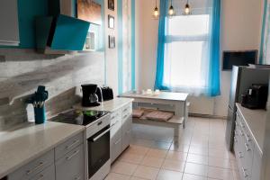 uma cozinha com armários azuis e um forno com placa de fogão em Ferienwohnung zum alten Hotel em Gramzow