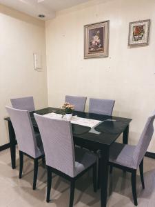 comedor con mesa negra y sillas en Bayan’s 2 storey apartment, en Surigao