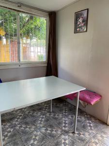 une table blanche et un banc dans une chambre avec fenêtre dans l'établissement Apartamento con 3 dormitorios para 8 personas con quincho, à Loncura