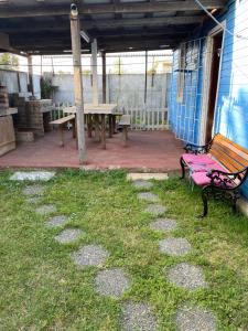 une terrasse avec une table de pique-nique et un banc dans l'établissement Apartamento con 3 dormitorios para 8 personas con quincho, à Loncura