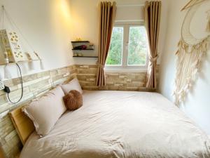 a bedroom with a bed with a teddy bear on it at Belle House Đà Lạt in Da Lat