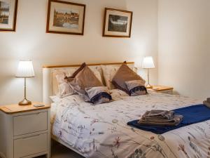 a bedroom with a bed with two lamps on it at Fig Tree Barn in Worth