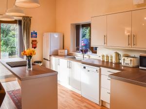 a kitchen with white cabinets and a white refrigerator at Fig Tree Barn in Worth
