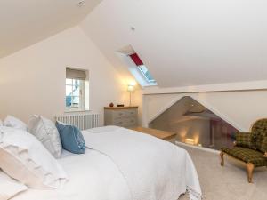 a bedroom with a white bed and a fireplace at Cranford Cottage in Saint Brides