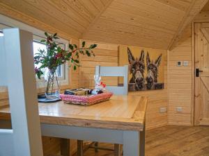 a kitchen with a table in a cabin with a painting of three animals at Cwt Celyn-qu7605 in Llangerniew