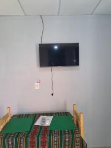 Pokój z łóżkiem i telewizorem na ścianie w obiekcie Depto monoambiente temporario w mieście Resistencia