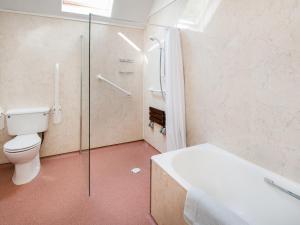 a bathroom with a toilet and a glass shower at Little Swinton - Garden Cottage in Swinton