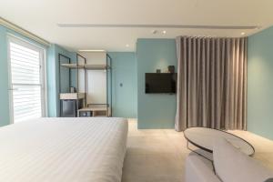 1 dormitorio con cama, sofá y TV en The Ocean House en Shimen