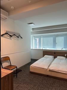 1 dormitorio con cama, ventana y silla en Room&Bed Fun stay KYOTO en Kioto