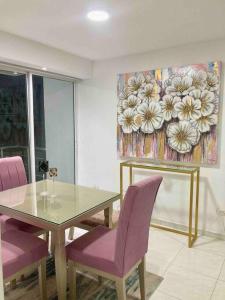 een eetkamer met een glazen tafel en paarse stoelen bij Increible apartamento en vup in Valledupar