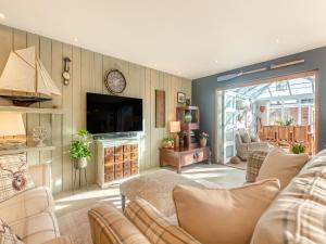 a living room with couches and a flat screen tv at Anchor Cottage in South Hayling