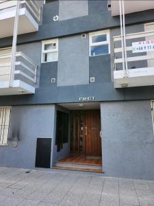 a building with a front entrance with a wooden door at Departamento Lo de Martha in Mar del Plata