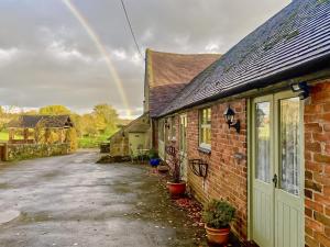 a rainbow in the sky over a brick house at Honeysuckle Cottage - Uk4177 in Mayfield