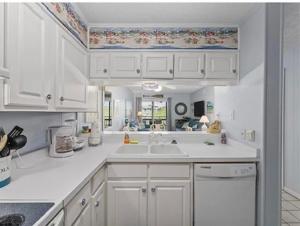 uma cozinha com armários brancos e um lavatório em Blue Beach Myrtle em Myrtle Beach