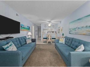 uma sala de estar com sofás azuis e uma televisão de ecrã plano em Blue Beach Myrtle em Myrtle Beach