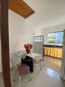 comedor con mesa, sillas y ventana en Casa Aconchegante, en Florianópolis